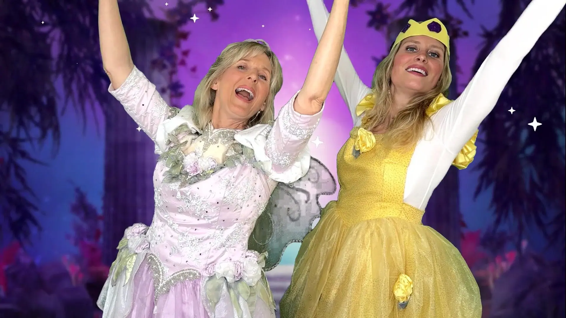 Two women in fairy costumes are holding their hands up.