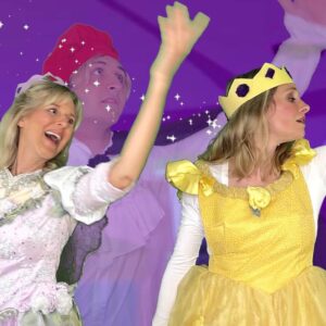 Two women in costumes are waving to the crowd.